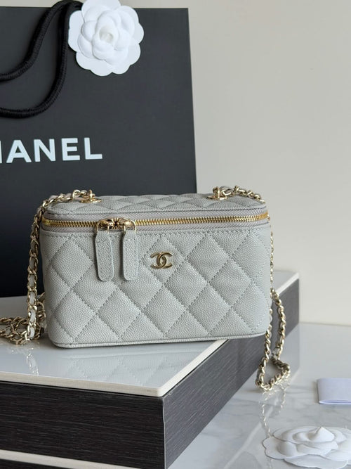 Small quilted Chanel handbag with gold chain shoulder strap and top zip.