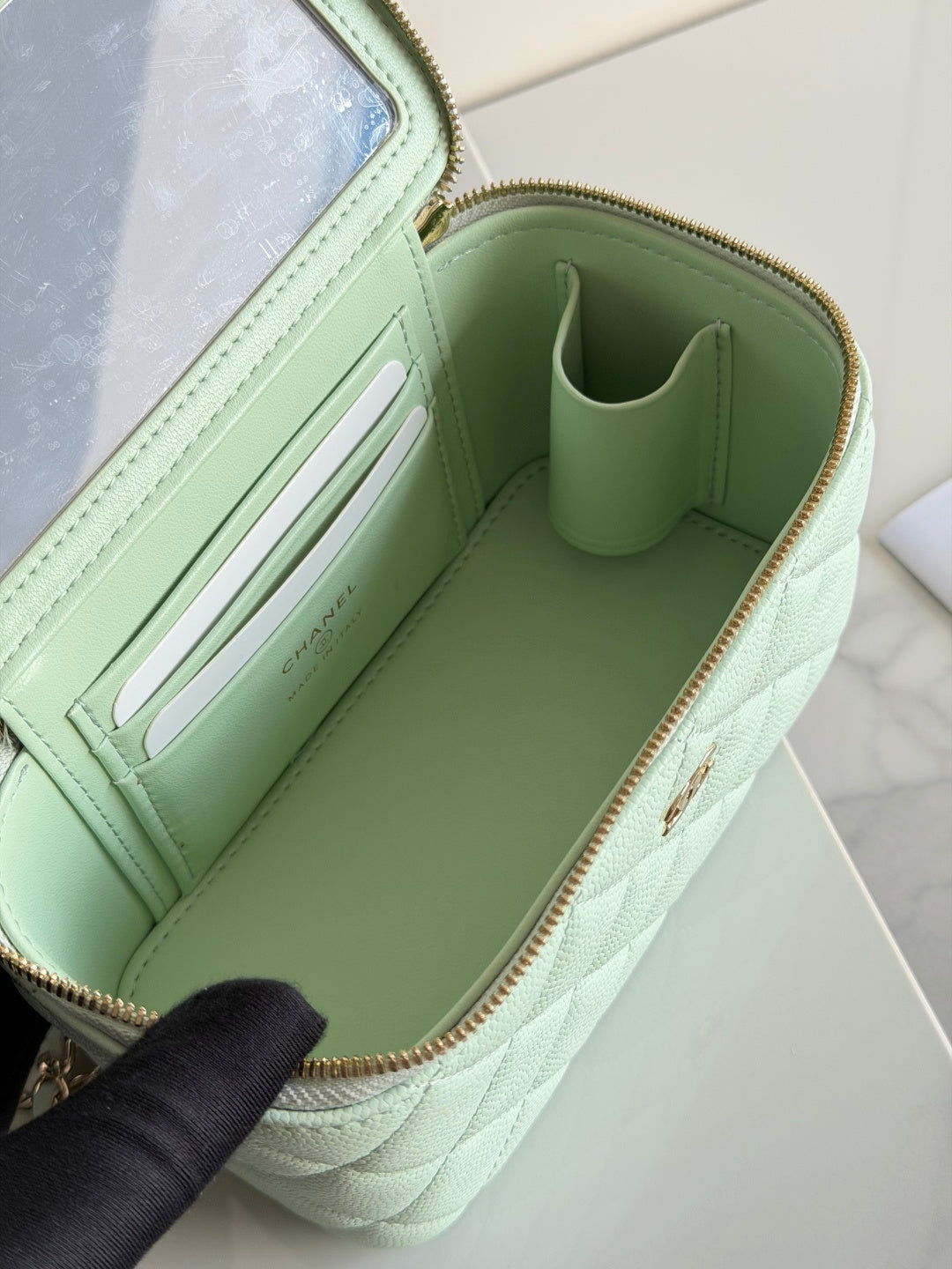 Mint green Chanel bag interior with zip pocket and card slots, leather-look lining