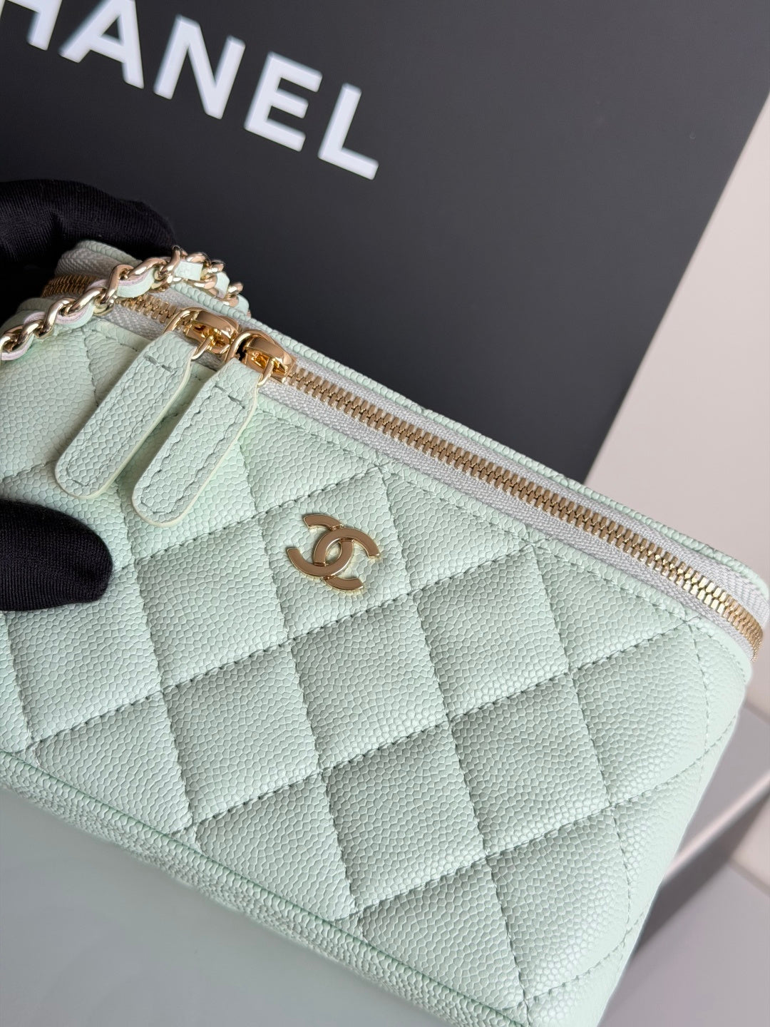 Mint quilted bag close-up with top zipper, CC emblem, and gold chain hardware