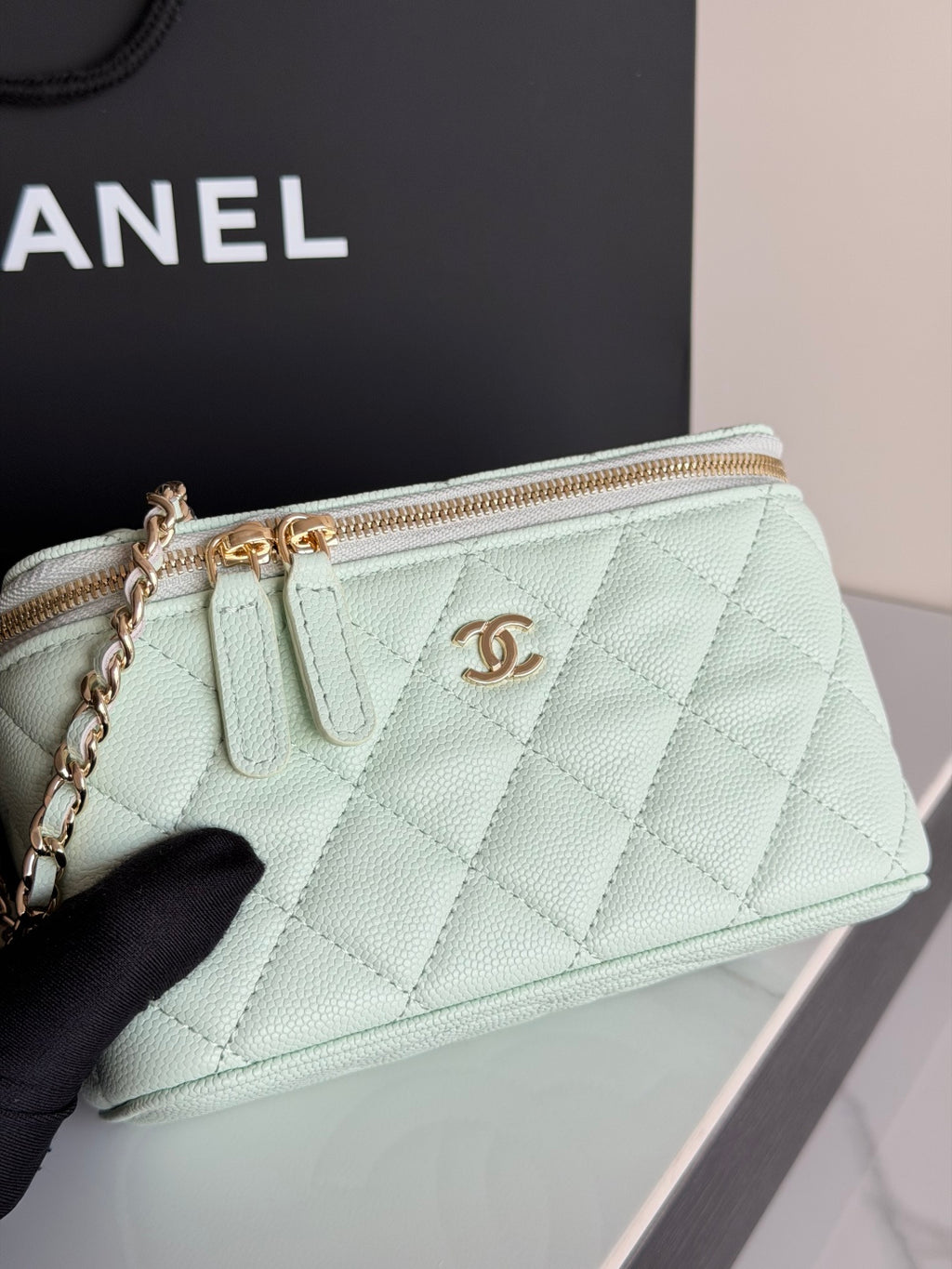 Mint quilted crossbody bag close-up with top zip, gold-tone logo, and chain strap