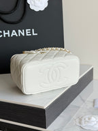 White quilted Chanel mini bag with embossed CC logo and gold chain strap