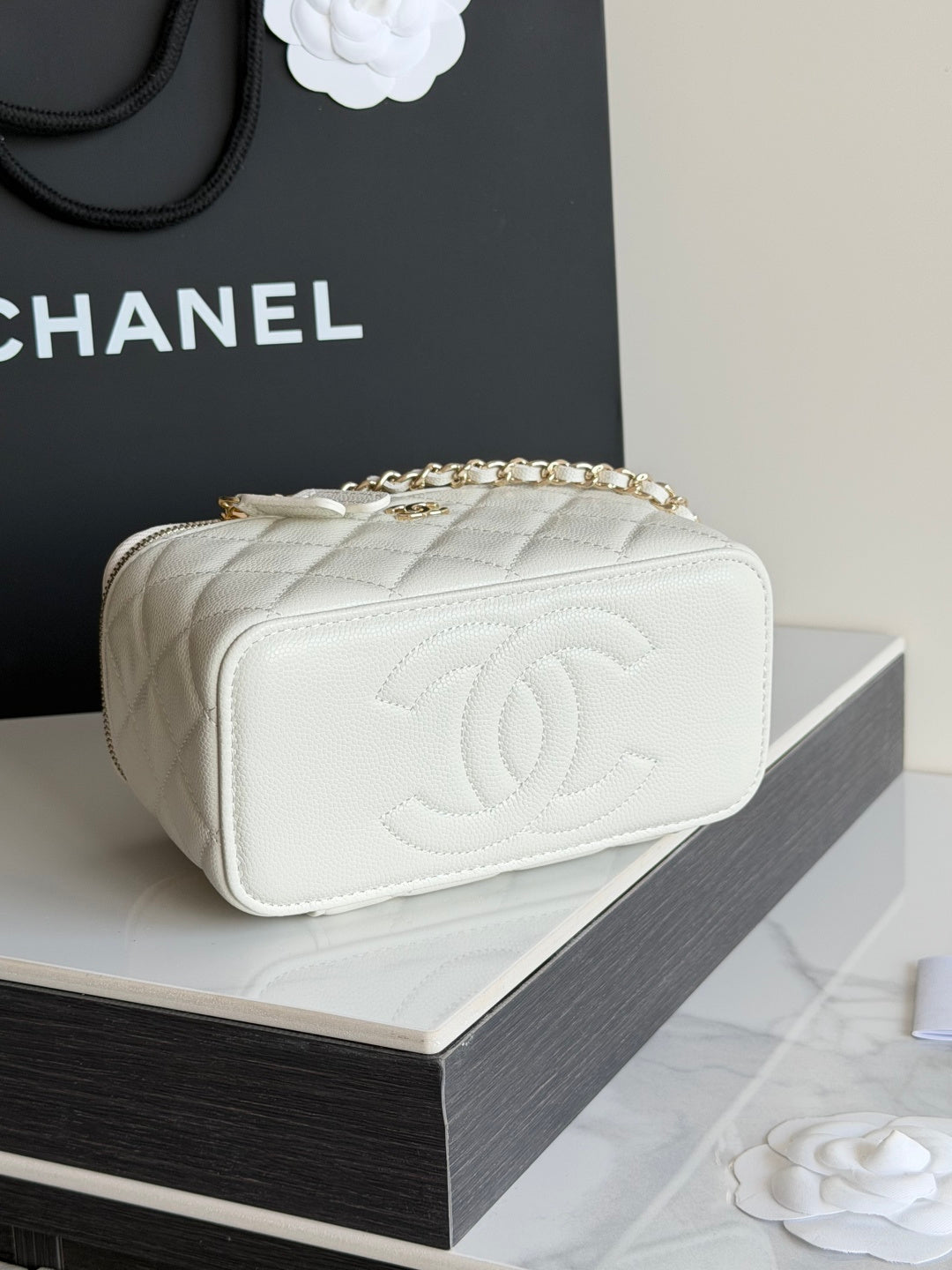 White quilted Chanel mini bag with embossed CC logo and gold chain strap