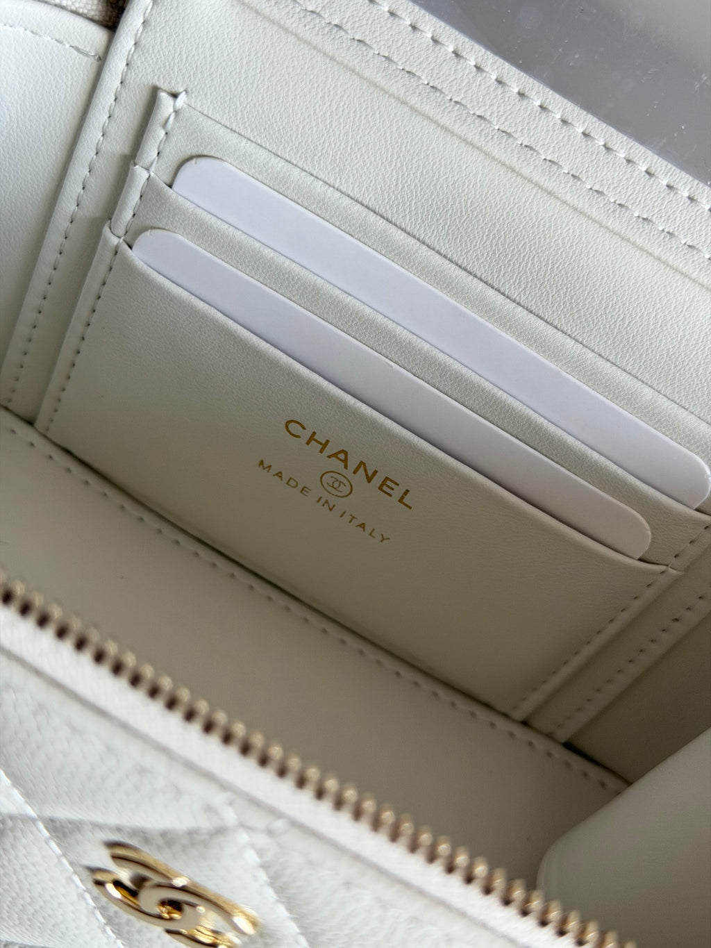 Chanel card slots inside white quilted mini bag with gold logo on lining