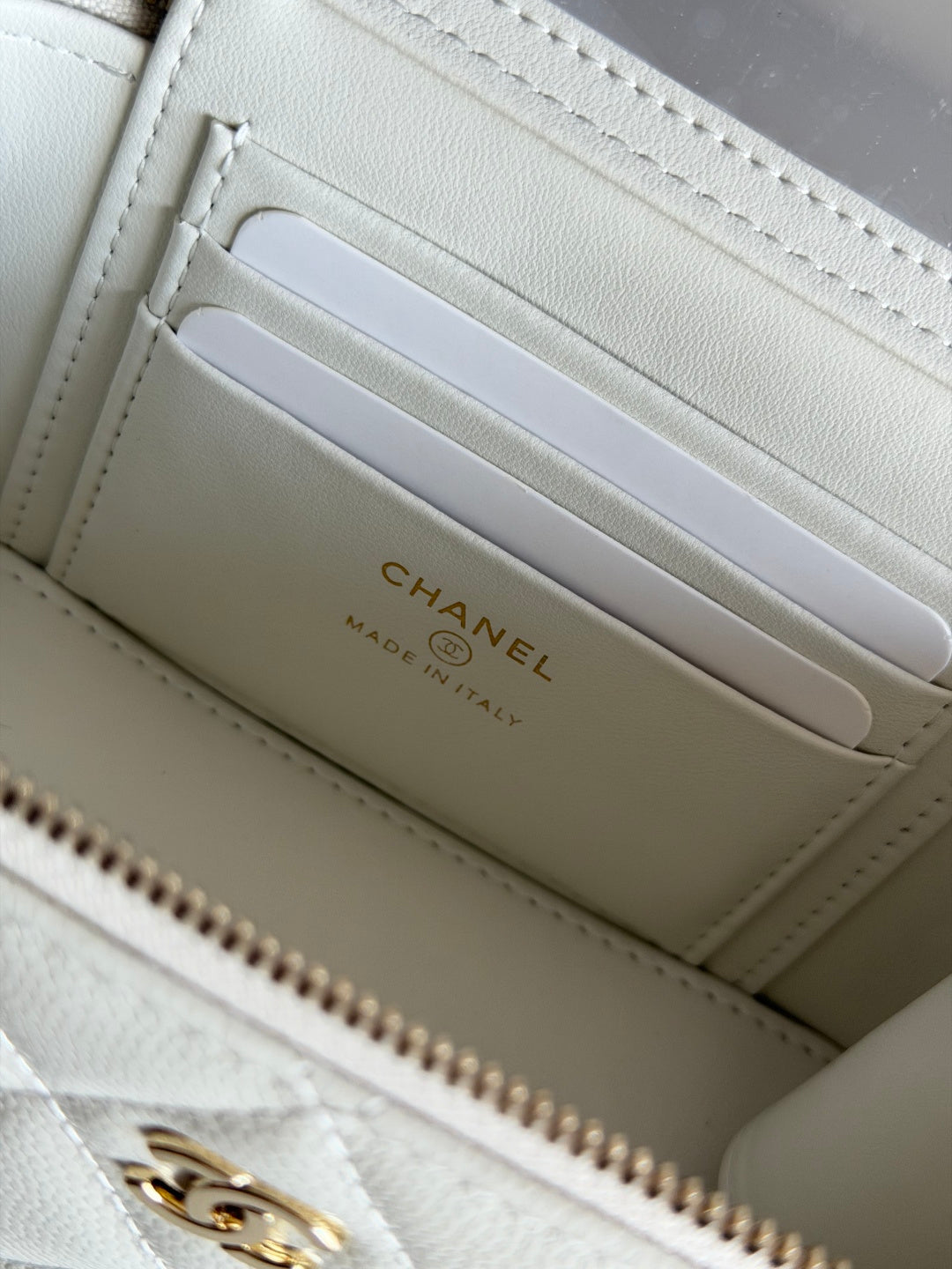 Chanel card slots inside white quilted mini bag with gold logo on lining