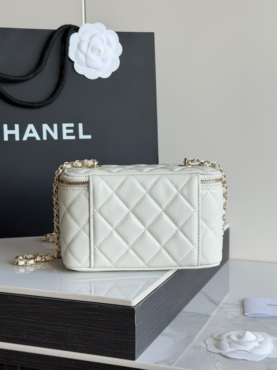White quilted Chanel mini crossbody bag with gold chain and zip top