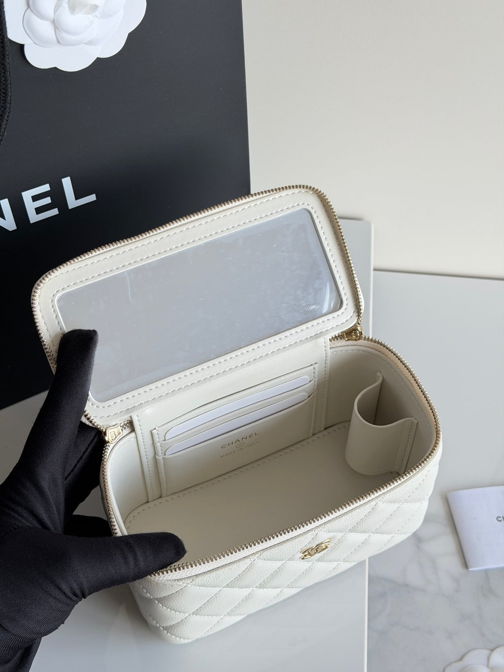 White Chanel mini bag interior open, showing card slots and zip compartment