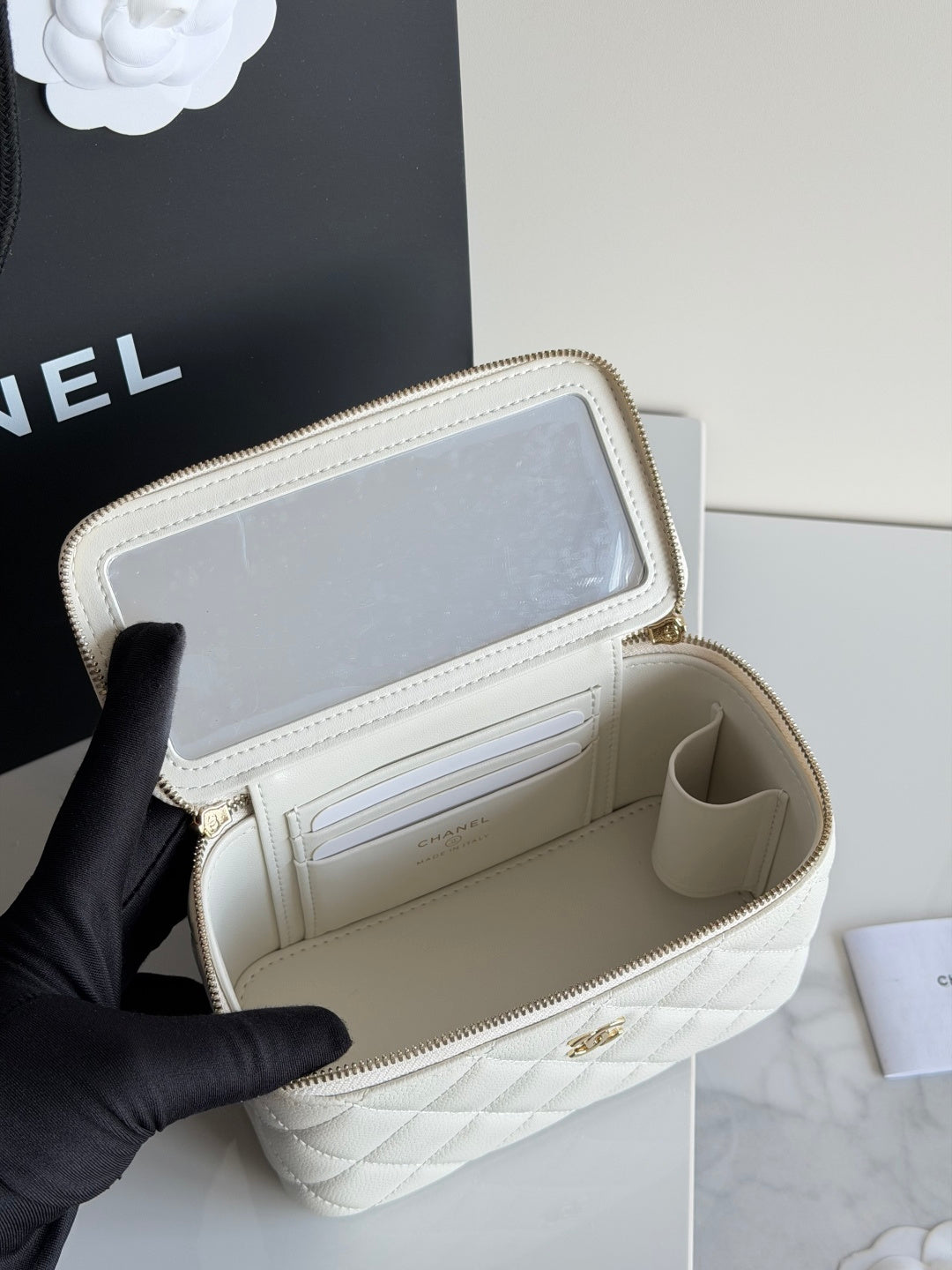 White Chanel mini bag interior open, showing card slots and zip compartment