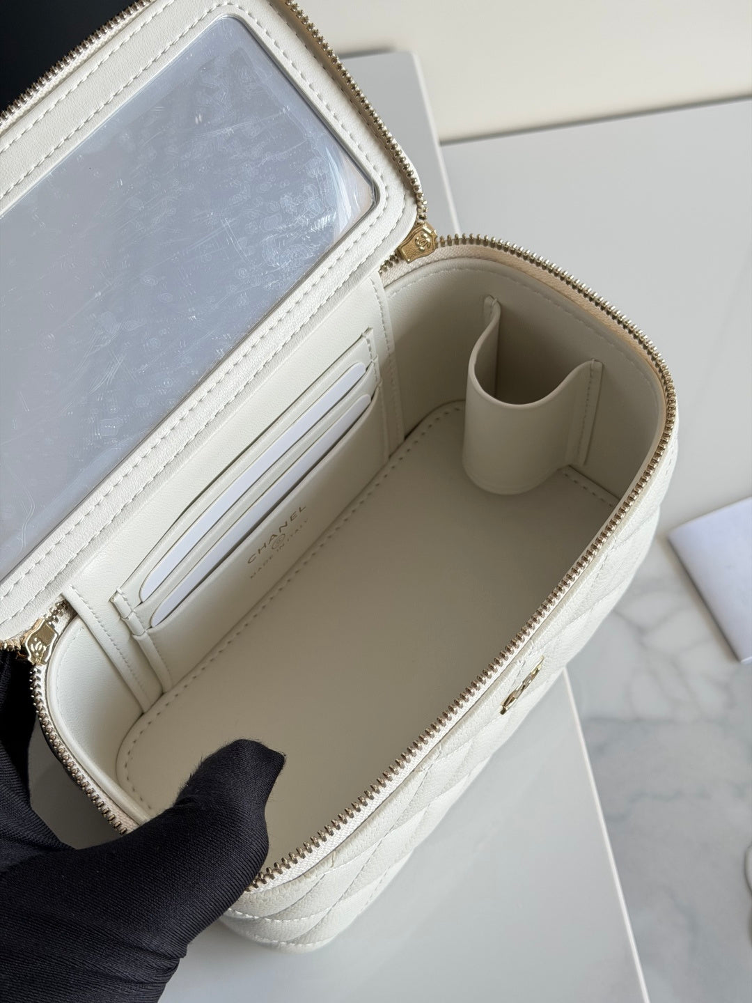 White Chanel mini bag interior with beige lining and card slots, open zip top