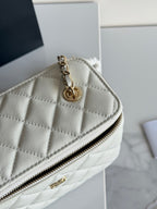 Chanel bag with quilted white leather, gold chain strap, and zip top close-up