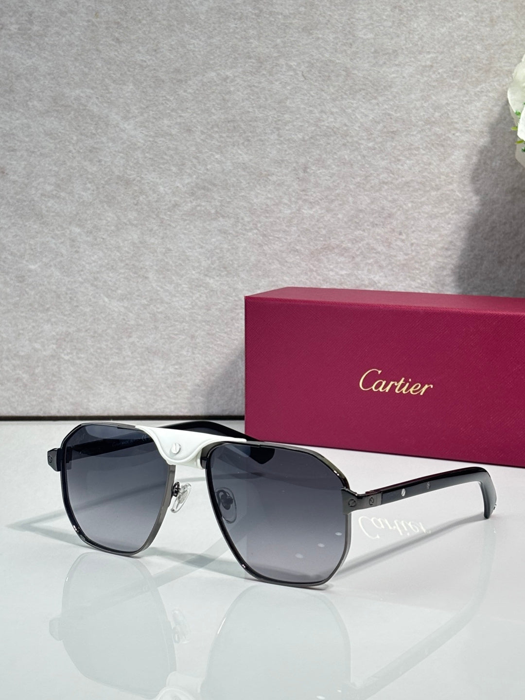 Cartier black aviator sunglasses with dark lenses and white temple accents