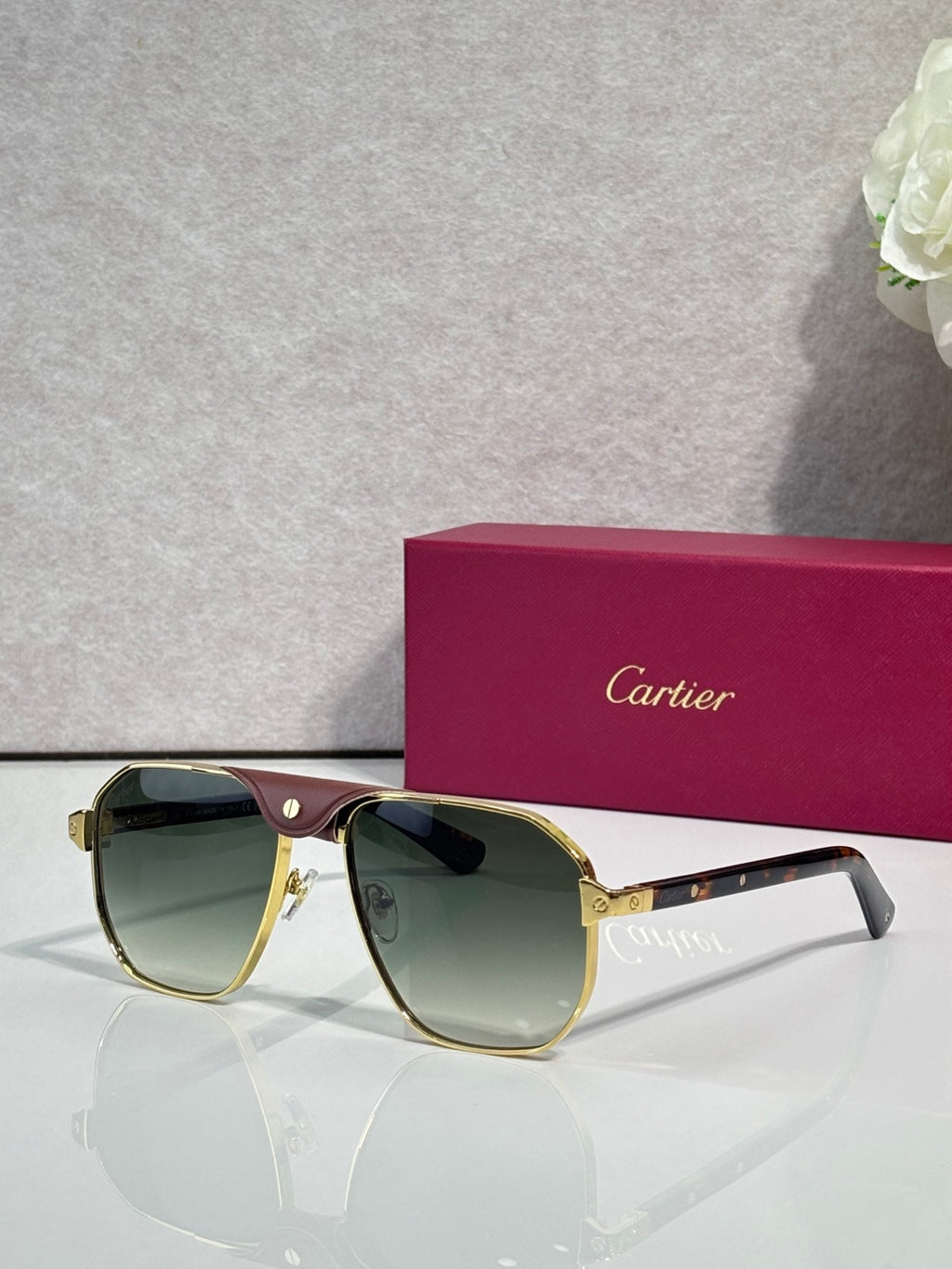 Cartier gold aviator sunglasses with green-tinted lenses and dark temples