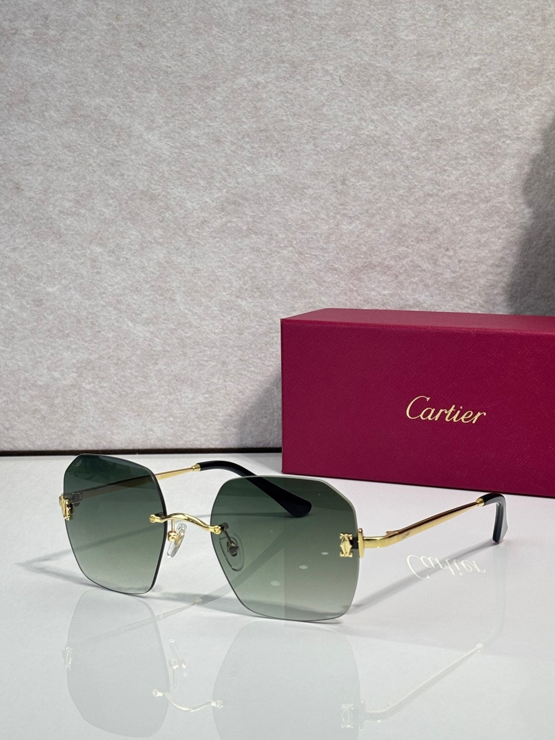 Gold-framed sunglasses with green-tinted lenses and dark bridge detail