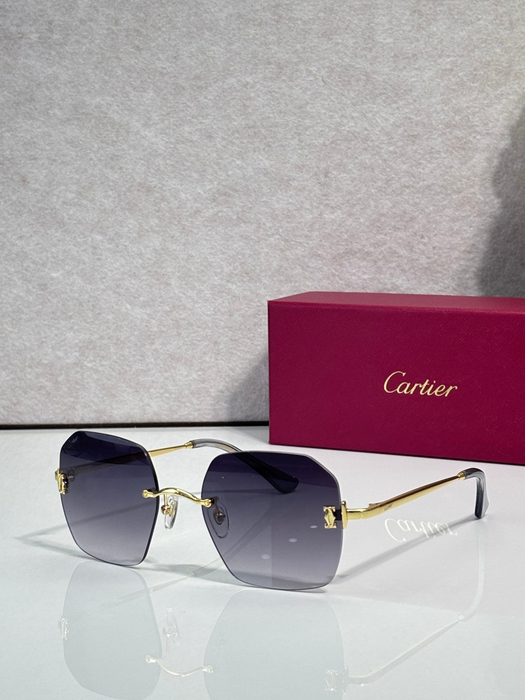 Gold-framed sunglasses with deep blue tinted lenses and curved shield frame
