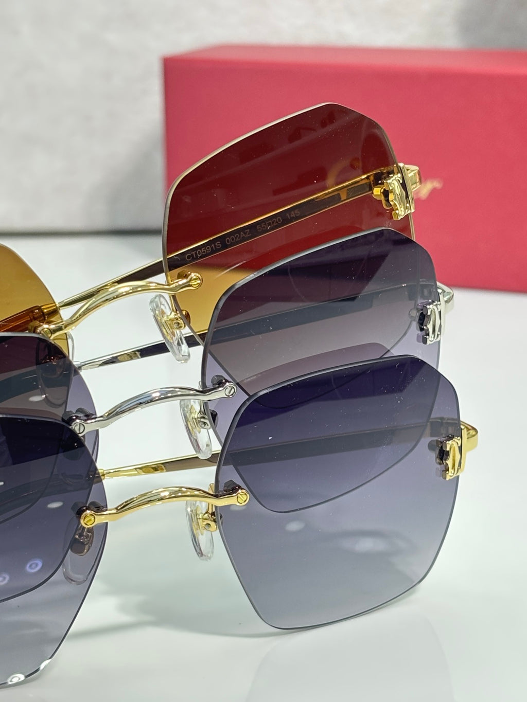 Sunglasses with gold and dark frames, featuring gradient tinted lenses