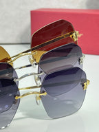 Sunglasses with gold and dark frames, featuring gradient tinted lenses