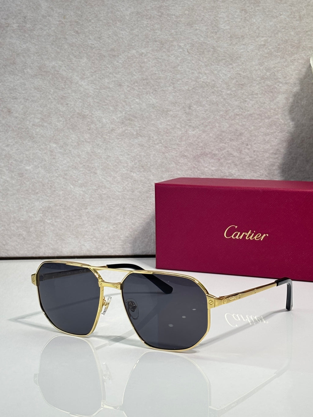 Cartier sunglasses with gold frames and dark tinted lenses