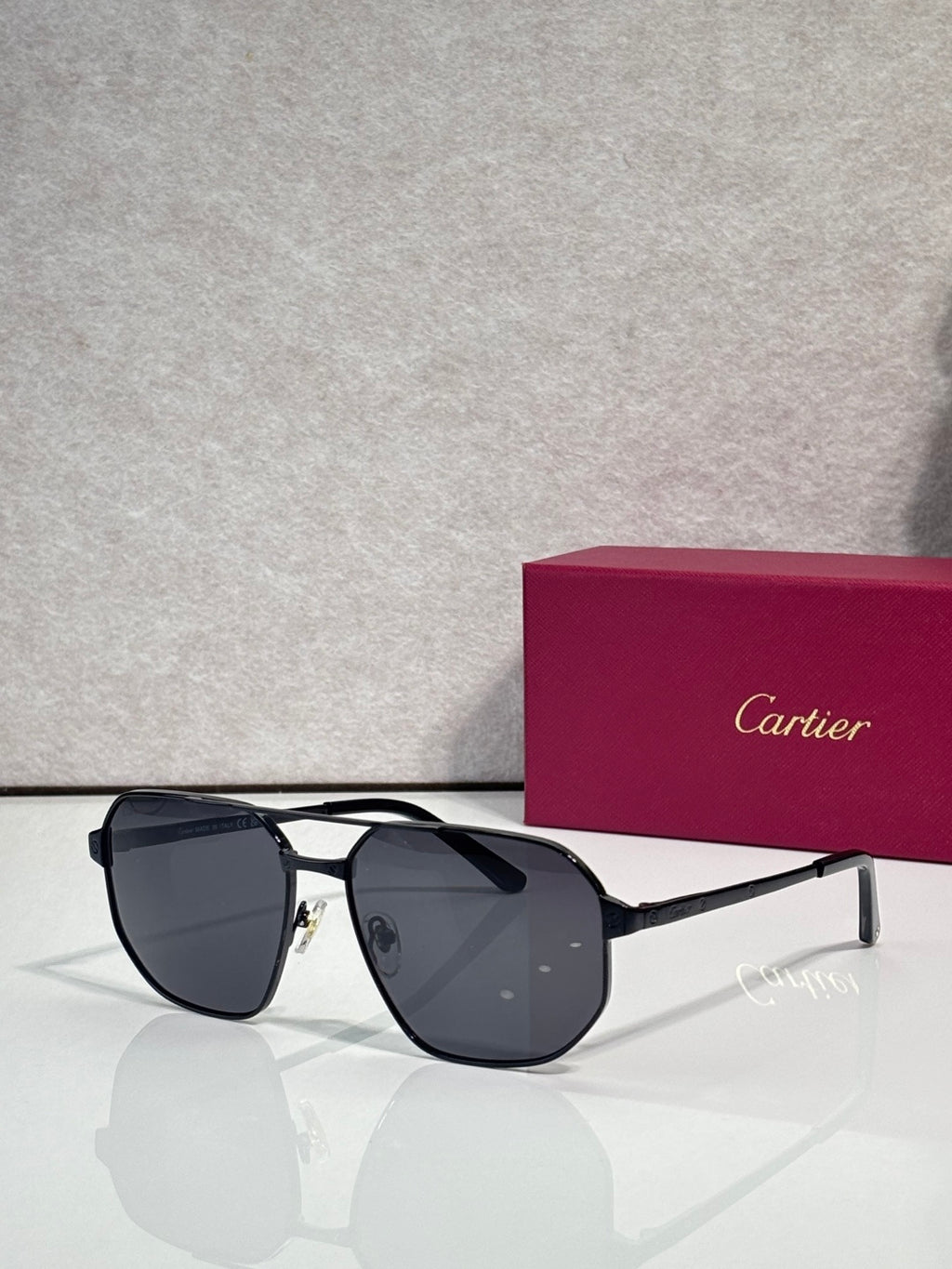Cartier sunglasses with black metal frames and square dark tinted lenses