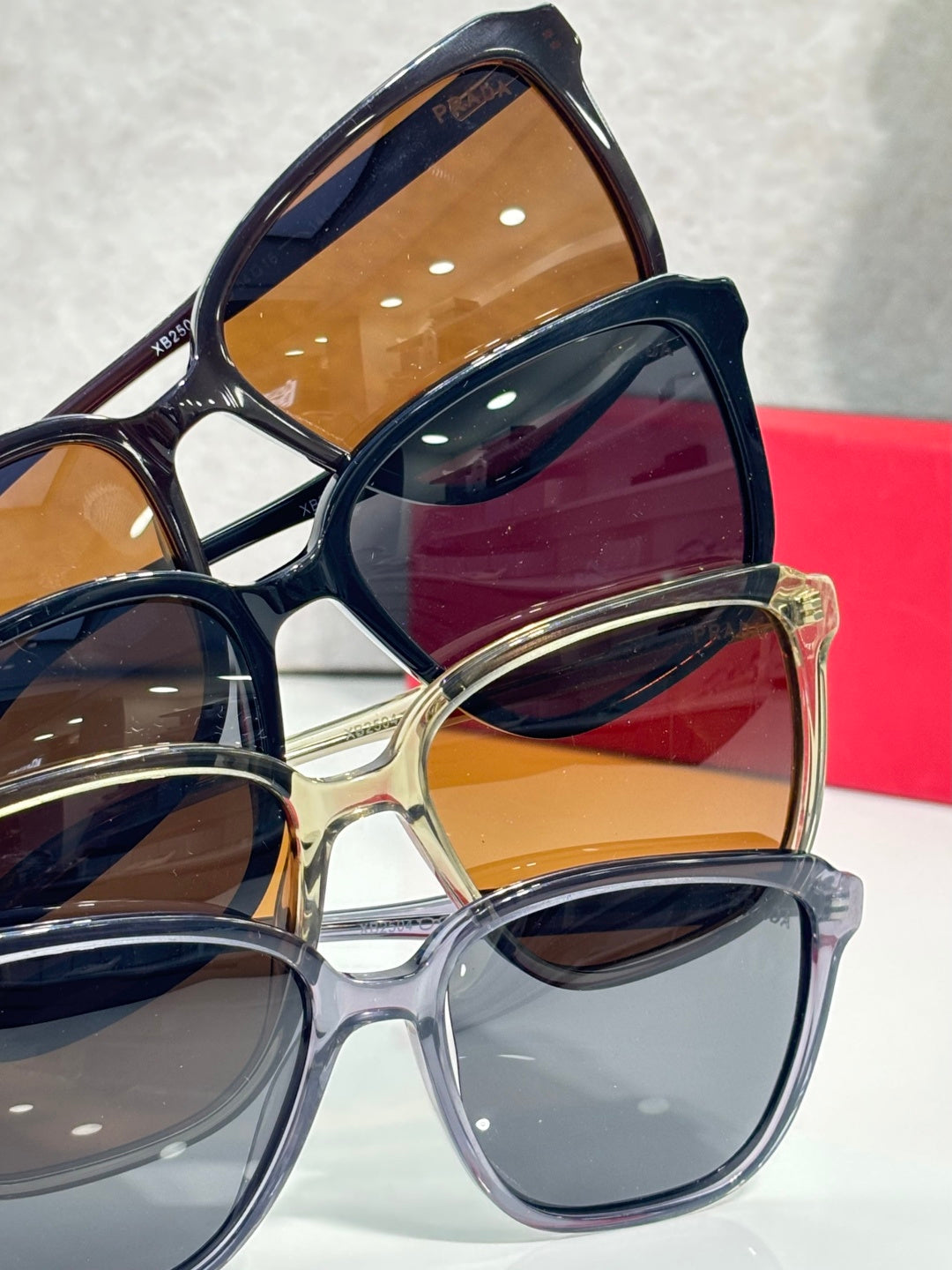 Stacked sunglasses with brown and dark lenses and Prada logos on temples