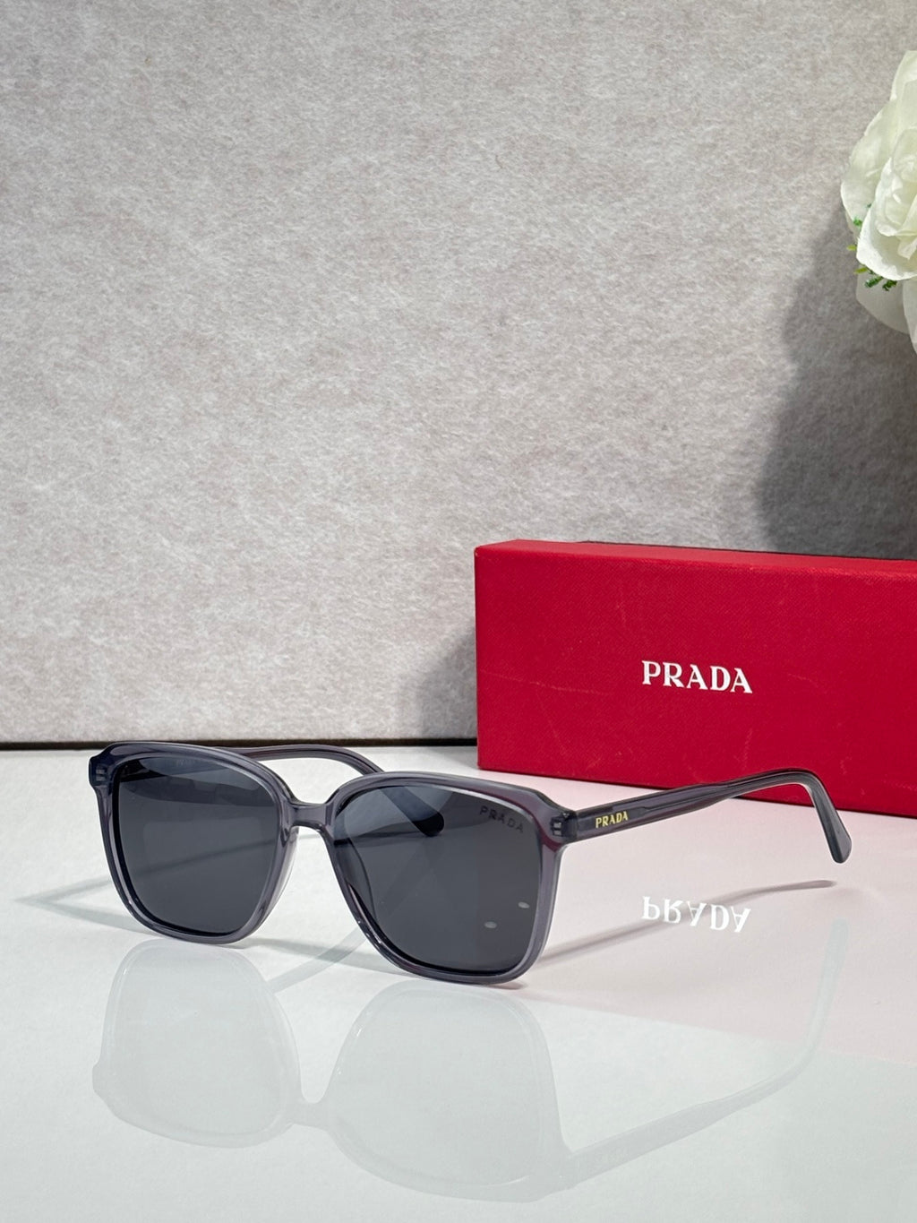 Black oversized sunglasses with dark lenses and Prada logo on temple
