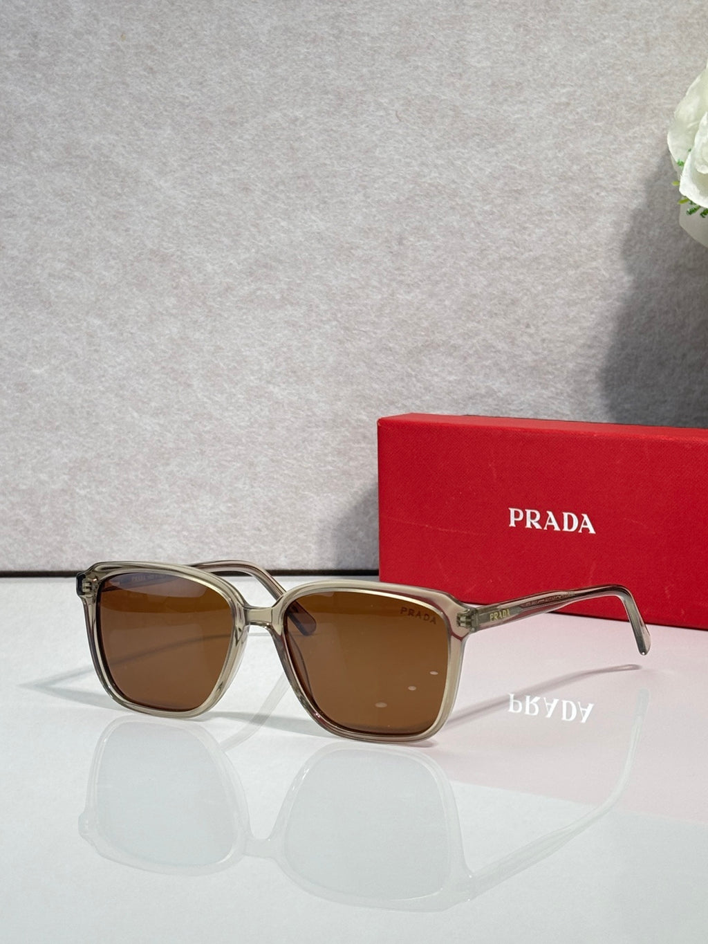 Gold and dark sunglasses with brown lenses and Prada logo on temples