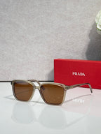Gold and dark sunglasses with brown lenses and Prada logo on temples