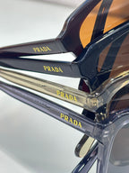Close-up of dark navy sunglasses frame and Prada logo temple