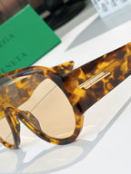 Bottega Veneta sunglasses close-up: tortoiseshell frame, round lens, gold temple bar