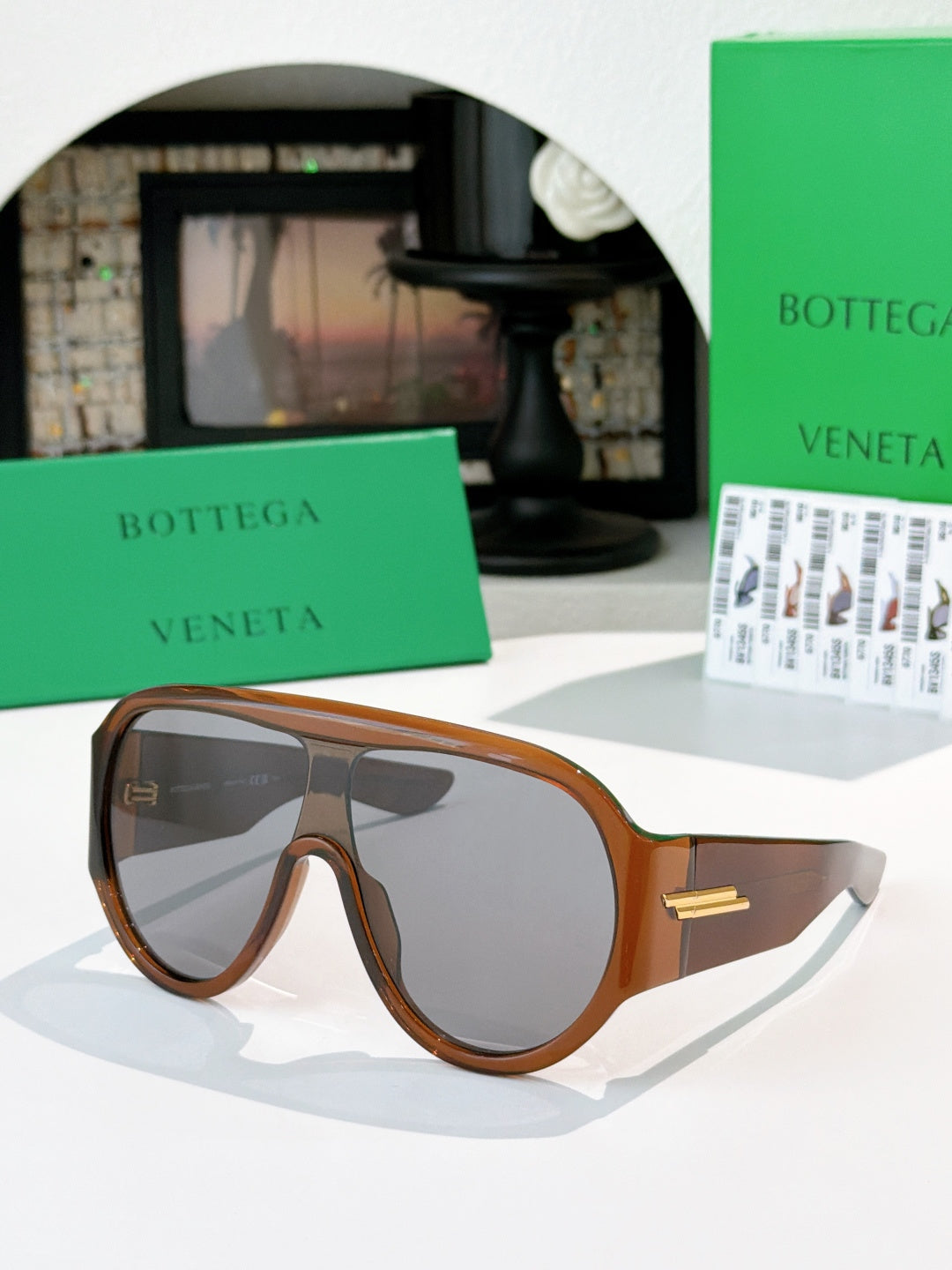 Bottega Veneta sunglasses with dark lenses and tortoiseshell frames, gold temple detail