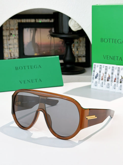Bottega Veneta sunglasses with dark lenses and tortoiseshell frames, gold temple detail