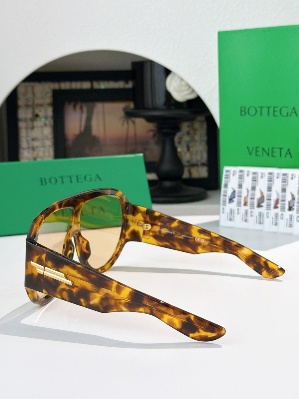 Bottega Veneta sunglasses side view: tortoiseshell temples with gold hinge bar