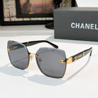 Cat-eye sunglasses with smoky gray lenses, black frame, and gold-tone hinges