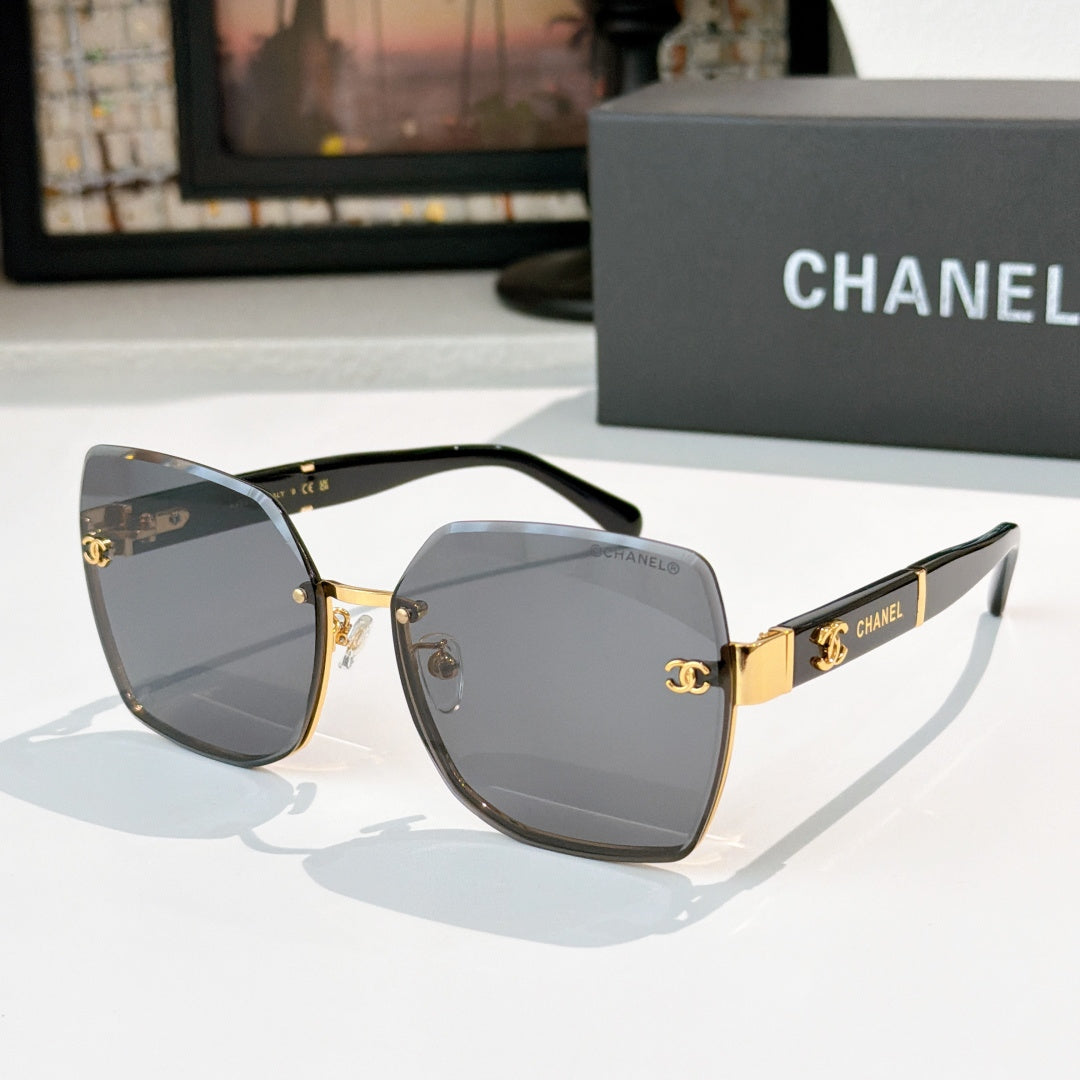 Cat-eye sunglasses with smoky gray lenses, black frame, and gold-tone hinges