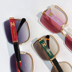 Close-up of sunglasses with purple, red, and brown gradient lenses and gold hardware