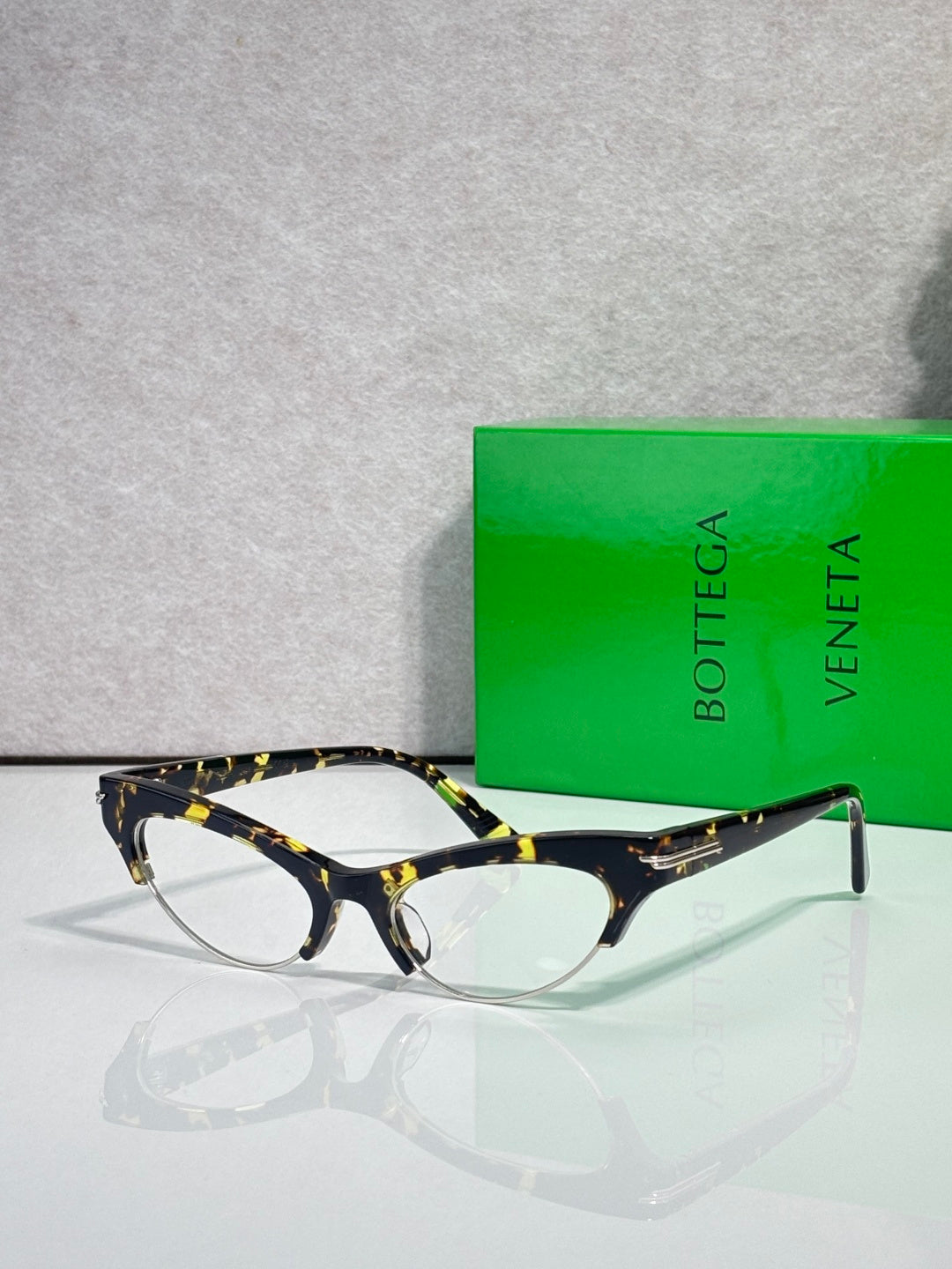 Bottega Veneta glasses with dark tortoiseshell frames and clear lenses