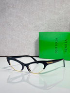 Bottega Veneta glasses with black frames, gold temple accents, and clear lenses