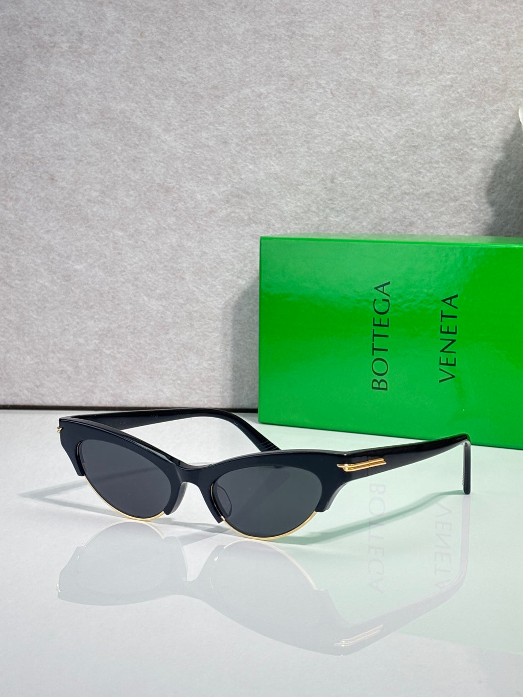 Eyeglasses with dark lenses, black frame, tortoise-pattern arms, and gold details.