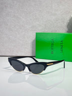 Eyeglasses with dark lenses, black frame, tortoise-pattern arms, and gold details.