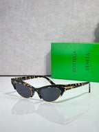 Eyeglasses with dark lenses, tortoise-pattern temples, and gold bridge accents.