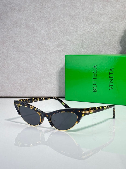 Eyeglasses with dark lenses, tortoise-pattern temples, and gold bridge accents.