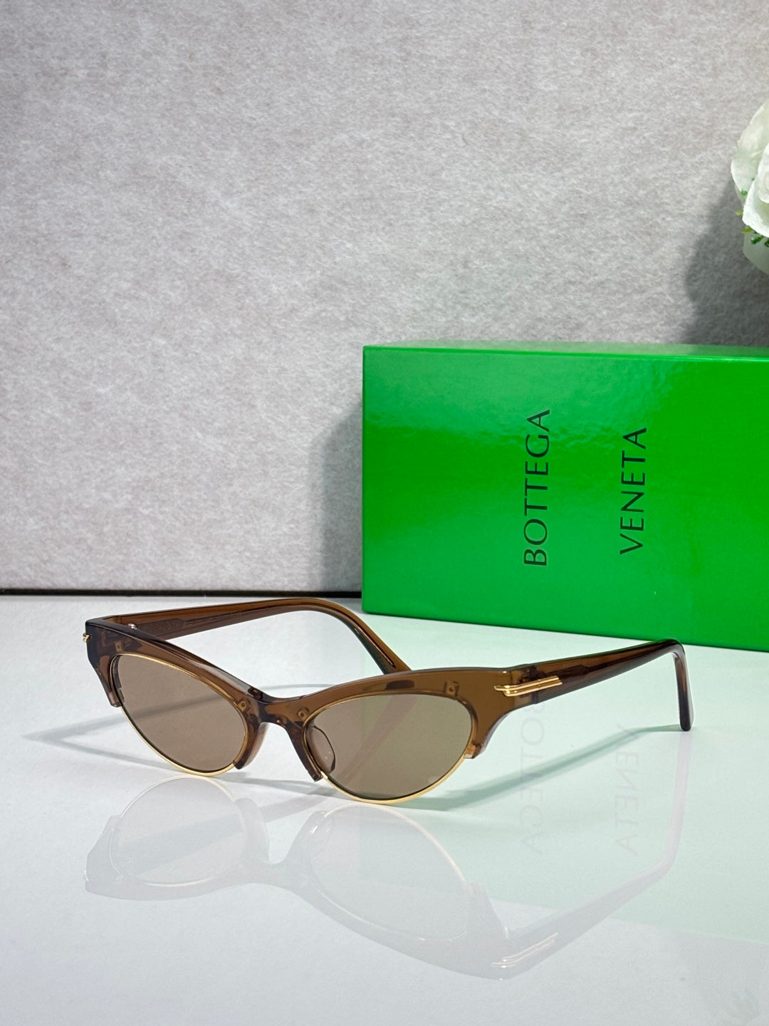Eyeglasses with brown frame and tinted lenses, with gold hinge details.