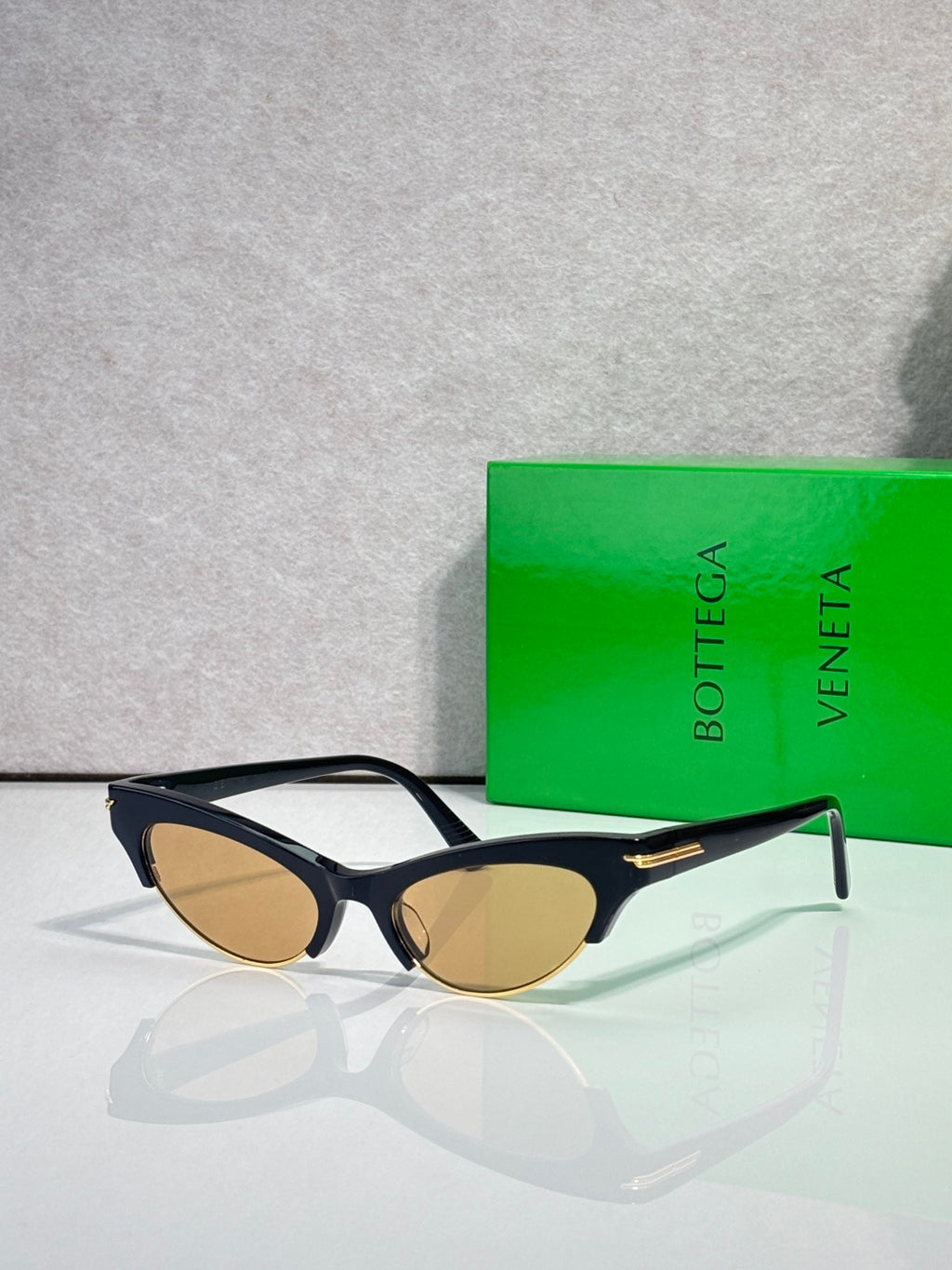 Eyeglasses with black frame, amber tinted lenses, and gold hinge accents.