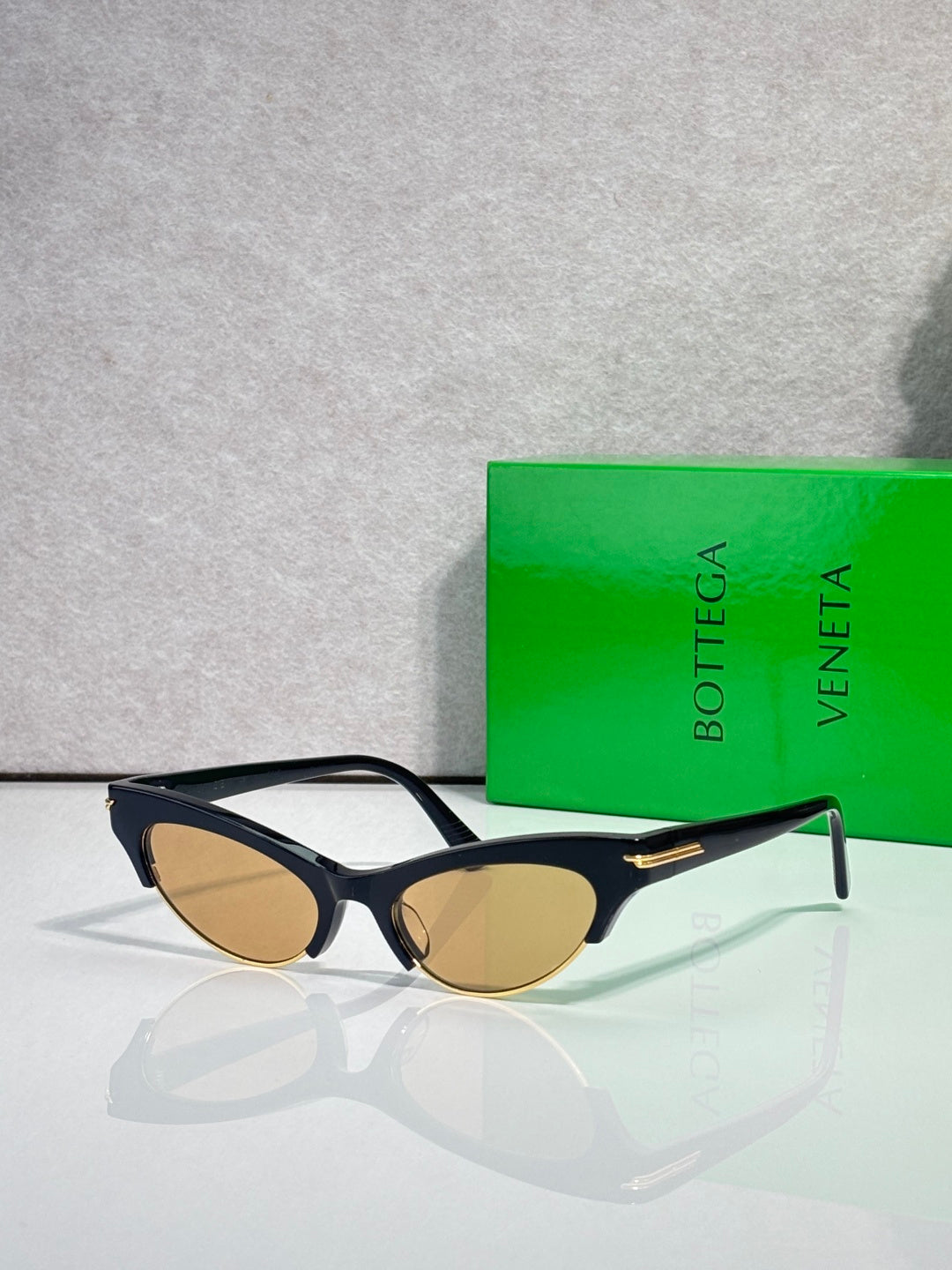 Eyeglasses with black frame, amber tinted lenses, and gold hinge accents.