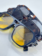 Sunglasses close-up with dark frames and reflective yellow lenses