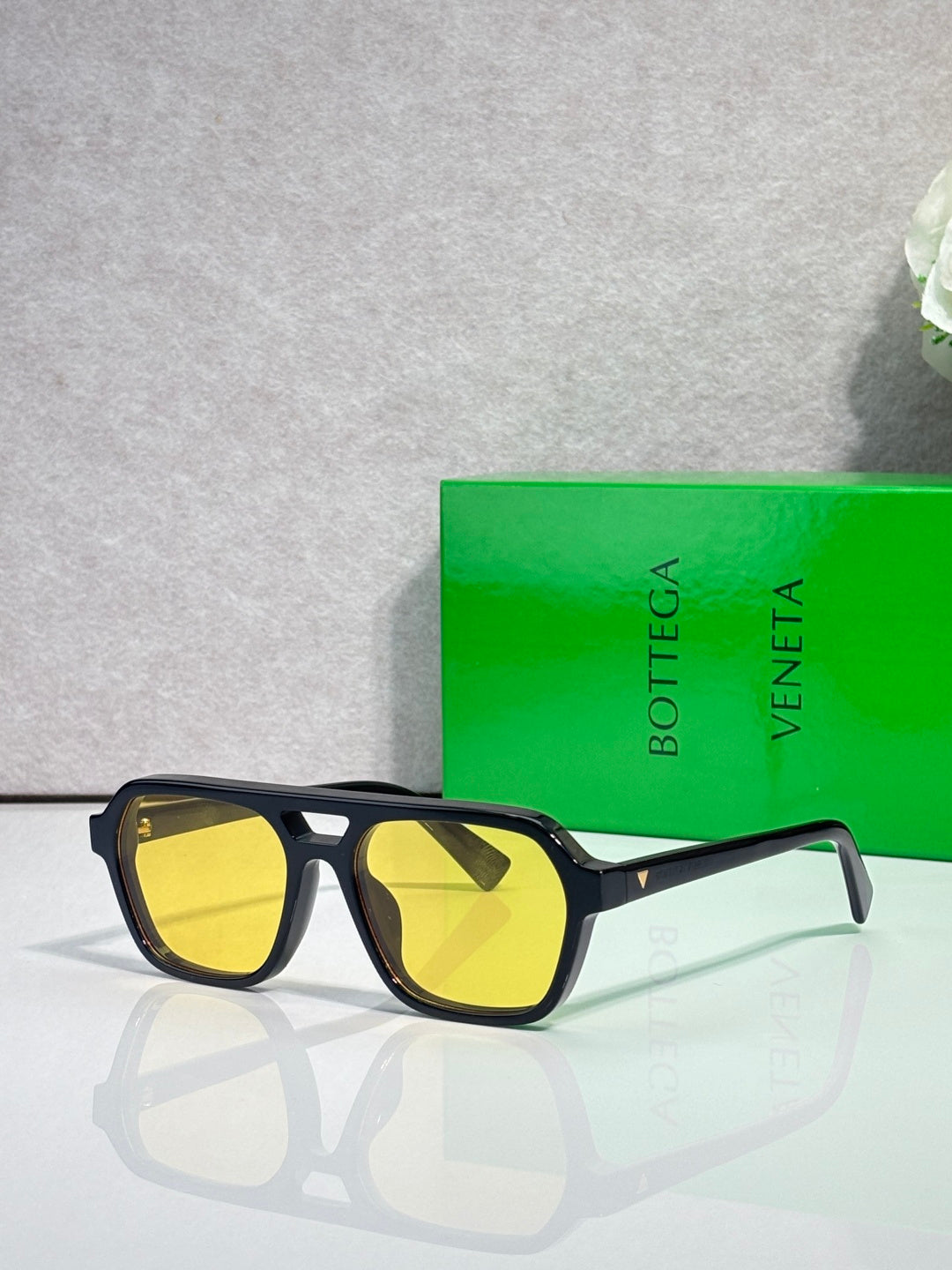 Sunglasses with yellow lenses and black tortoiseshell frame, side angle