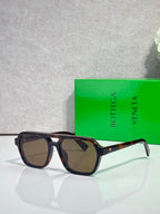 Sunglasses with dark lenses and black tortoiseshell frame, angled front