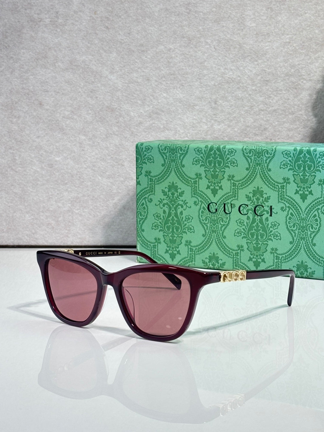 Gucci cat-eye sunglasses with maroon frames and rose-tinted lenses