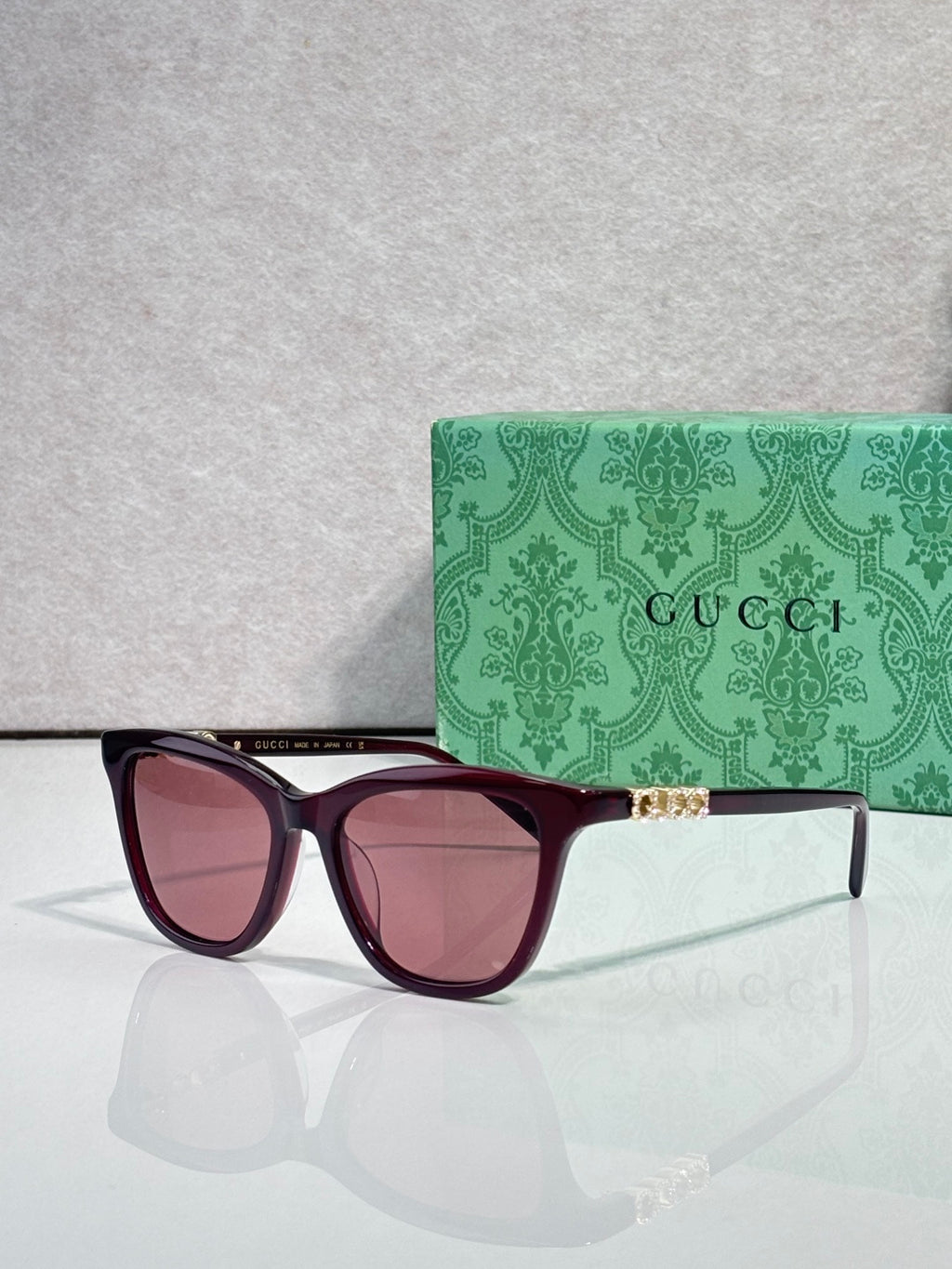 Gucci cat-eye sunglasses with maroon frames and pink-tinted lenses