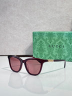 Gucci cat-eye sunglasses with maroon frames and pink-tinted lenses