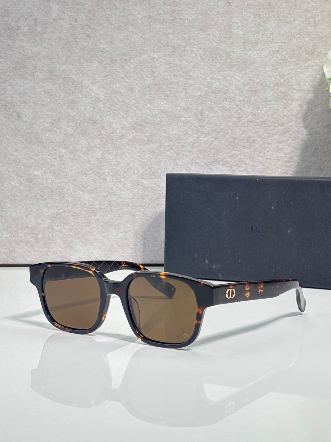 Tortoiseshell sunglasses with brown lenses and clear-tinted temple detail