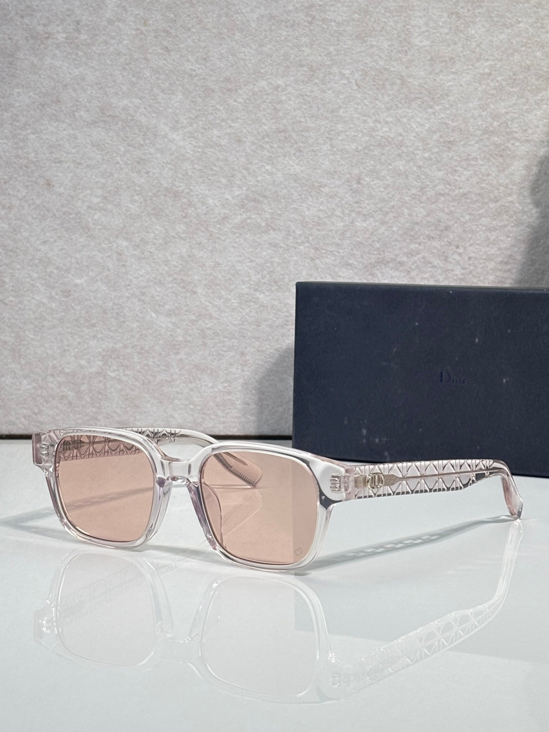 Silver sunglasses with pink-tinted lenses and geometric temple detailing